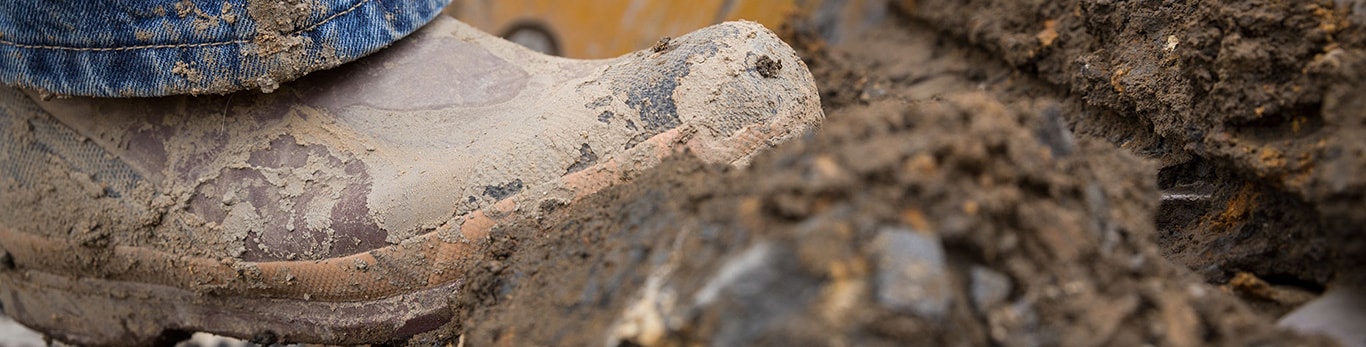 Botas cubiertas de lodo que avanzan