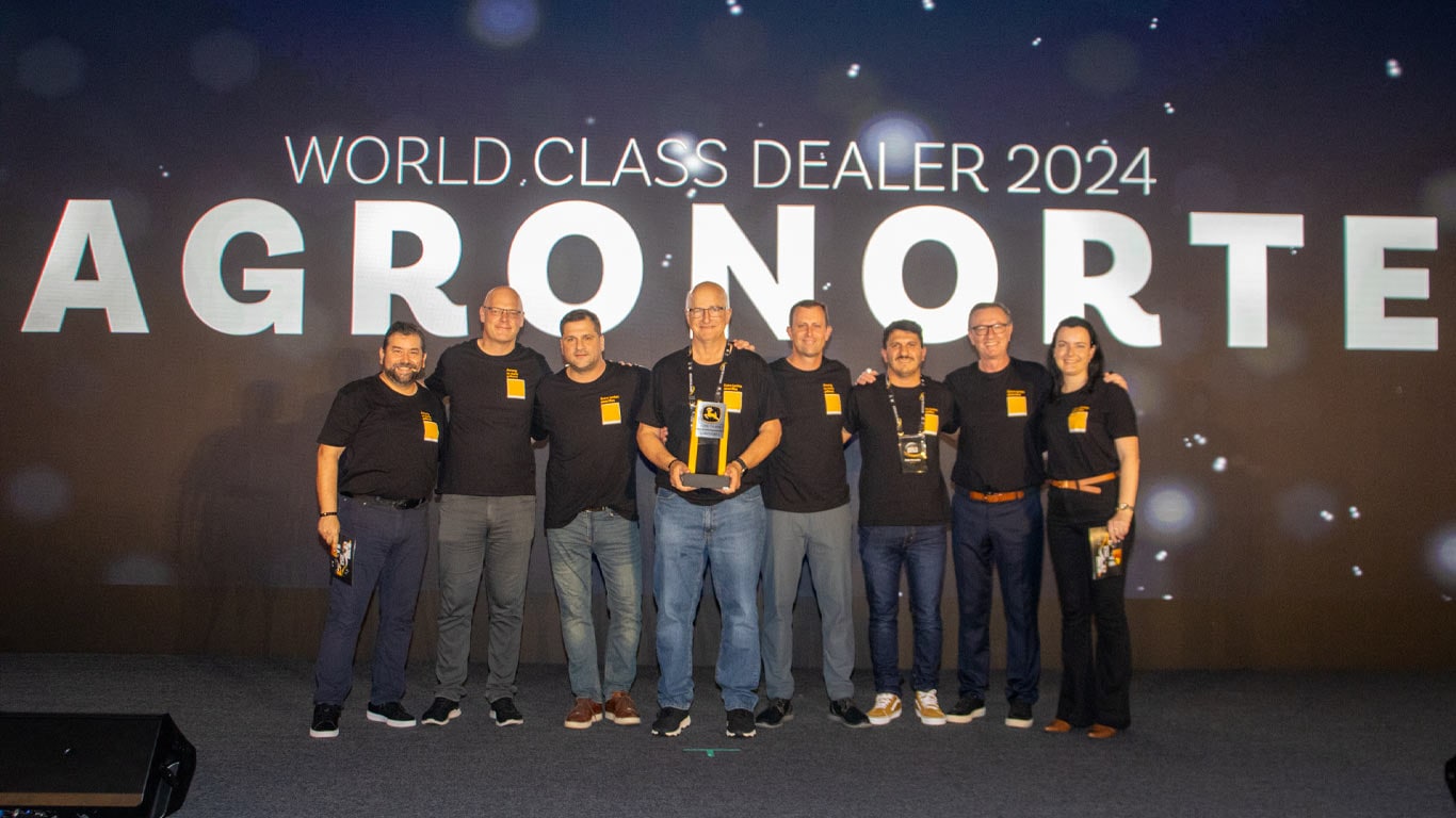 Un grupo de 8 personas de Agronorte y John&nbsp;Deere están celebrando el premio en el evento World Class Dealer.