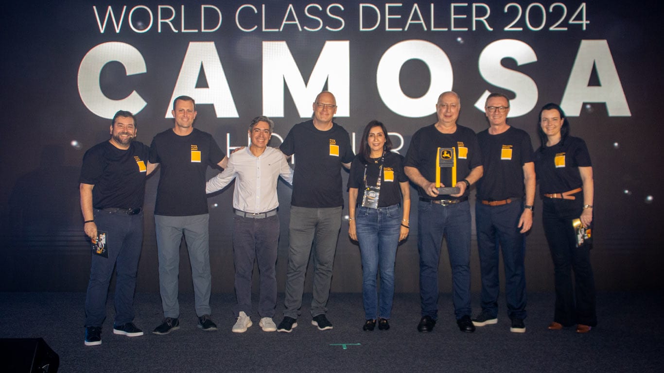 Un grupo de 8 personas de Camosa y John&nbsp;Deere están celebrando el premio en el evento World Class Dealer.