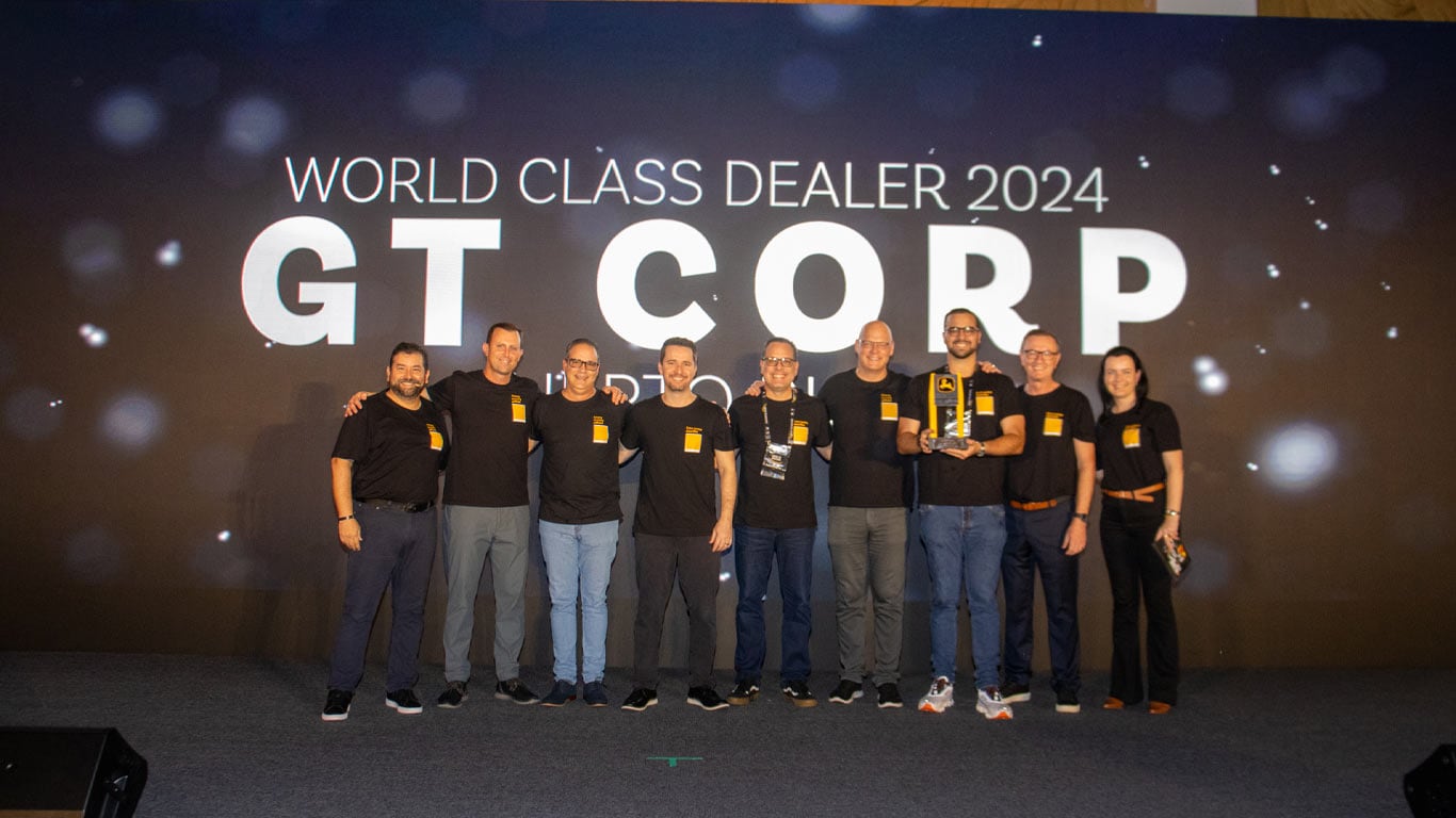 Un grupo de 9 personas de GT Corp y John&nbsp;Deere están celebrando el premio en el evento World Class Dealer.