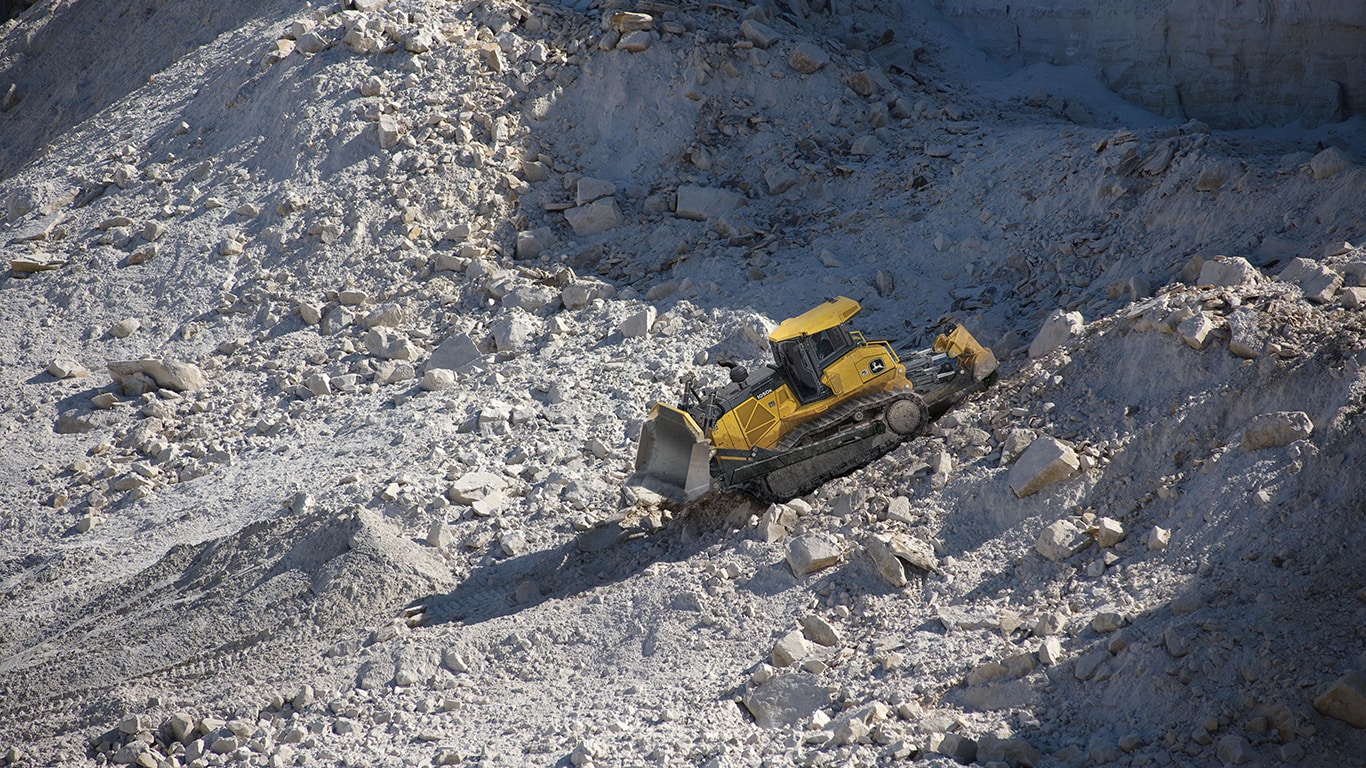 Un bulldozer 1050K empujando piedras en un sitio de trabajo de cantera.