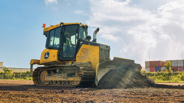 Vista del lado derecho de un bulldozer 650P empujando tierra en un lugar de trabajo.