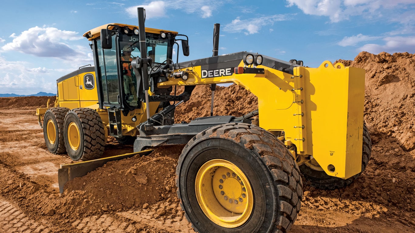 Una motoniveladora John Deere nivela la tierra en un sitio de construcción