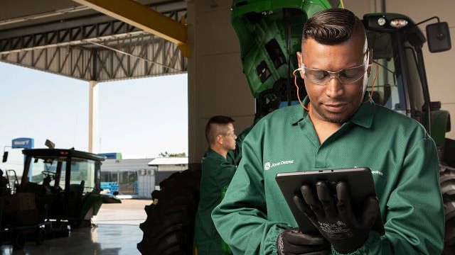 man looking at a tablet at a Deere dealership