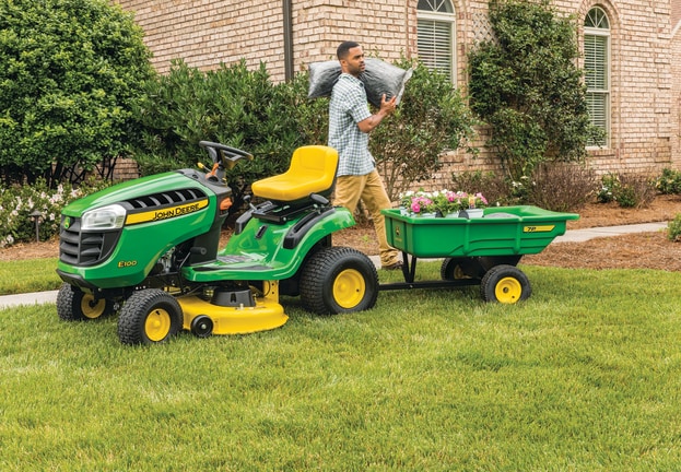 Tractor de Jardín E100 con carro de utilidad de John Deere.