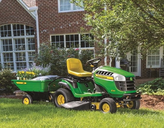 Tractor de Jardín E130 con carro de utilidad de John Deere.