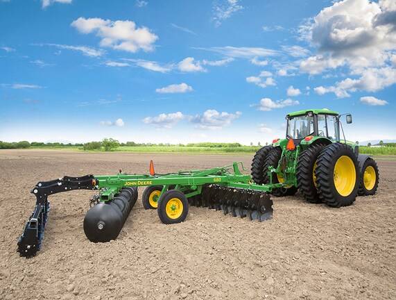 Rastra 680 en el campo con tractor John Deere.