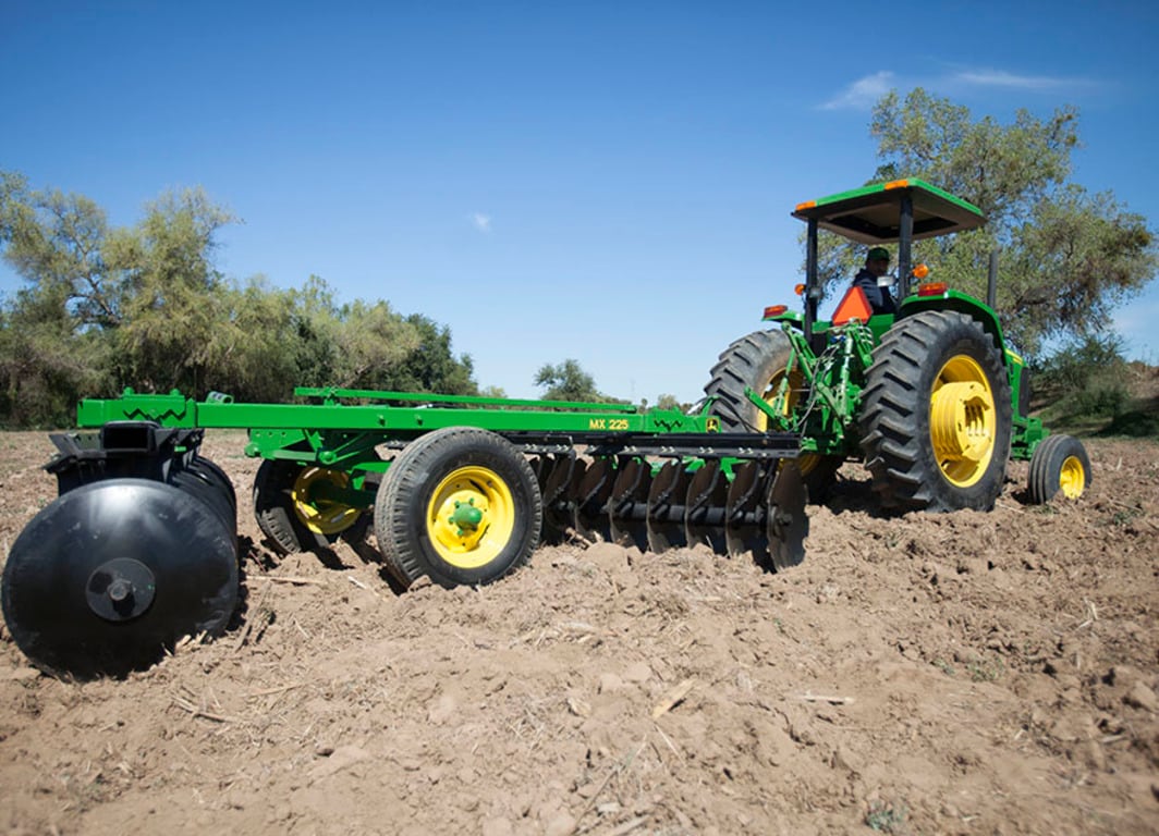 Rastra MX225 en el campo con tractor John Deere.