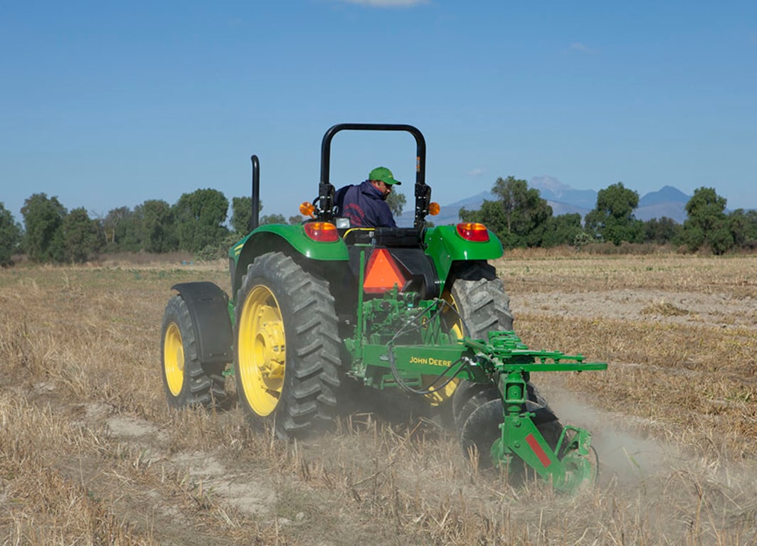 Arado de Disco 645 en el campo con tractor John Deere.