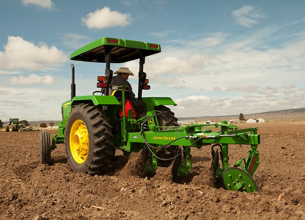 Vista lateral del Arado de Disco 624 con Tractor John Deere.