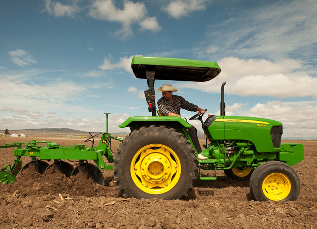 Arado de Disco 624 en el campo con tractor John Deere.