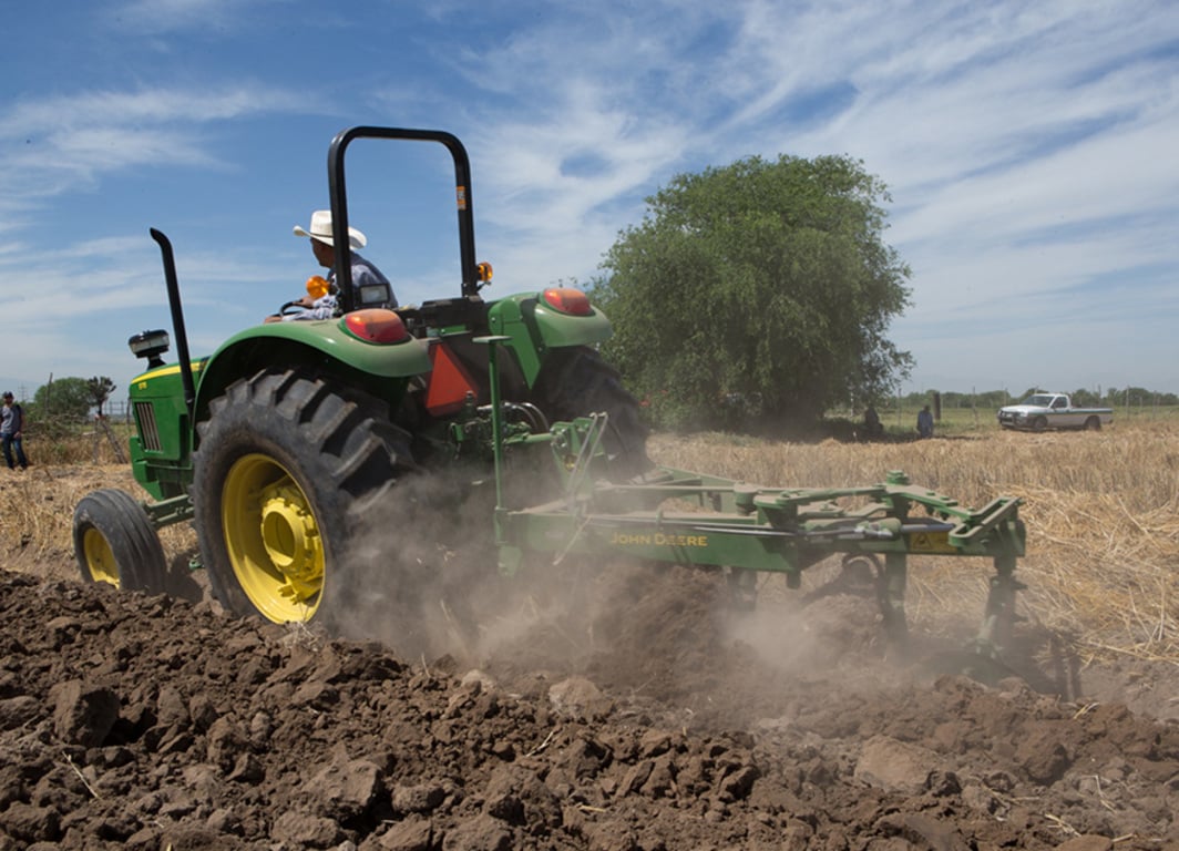 Arado de Disco 635 en el campo con tractor John Deere.