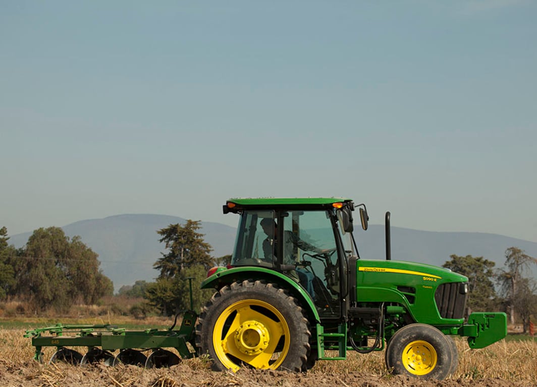 Vista lateral del Arado de Disco 645 con Tractor John Deere.
