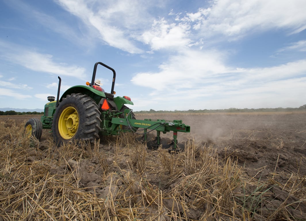 Vista lateral del Arado de vertedera 945 con Tractor John Deere.