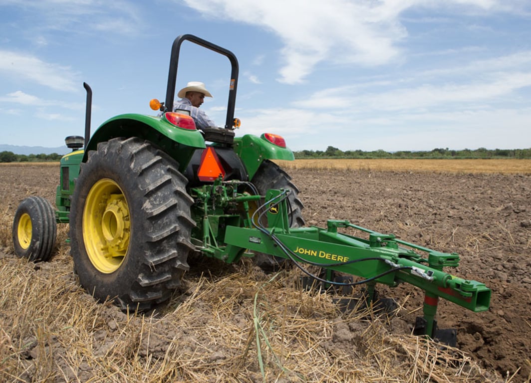 Vista lateral del Arado de vertedera 945 con Tractor John Deere.