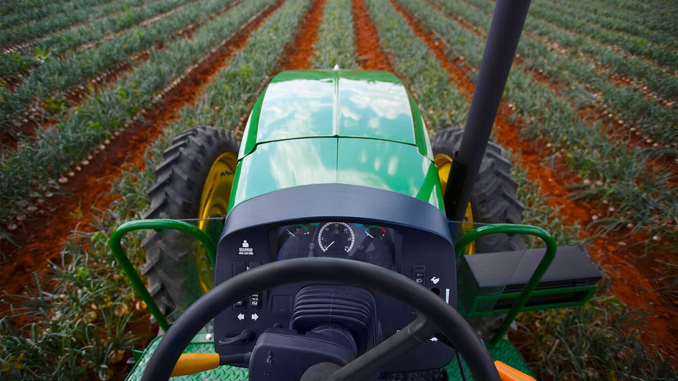 vista del tractor 6105E desde el asiento del conductor mientras trabaja el campo