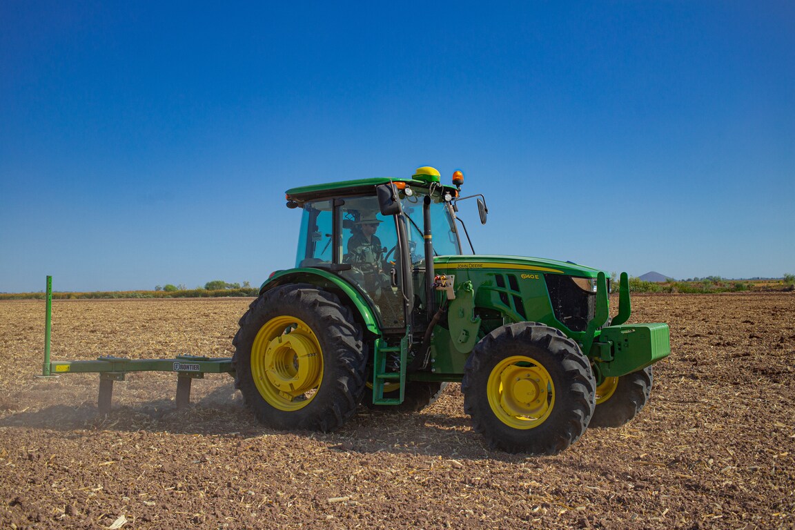 Imagen de tractor 6140E labrando campo con roturador