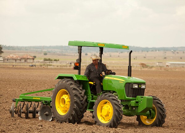 Tractor 5065E con la rastra de John Deere.